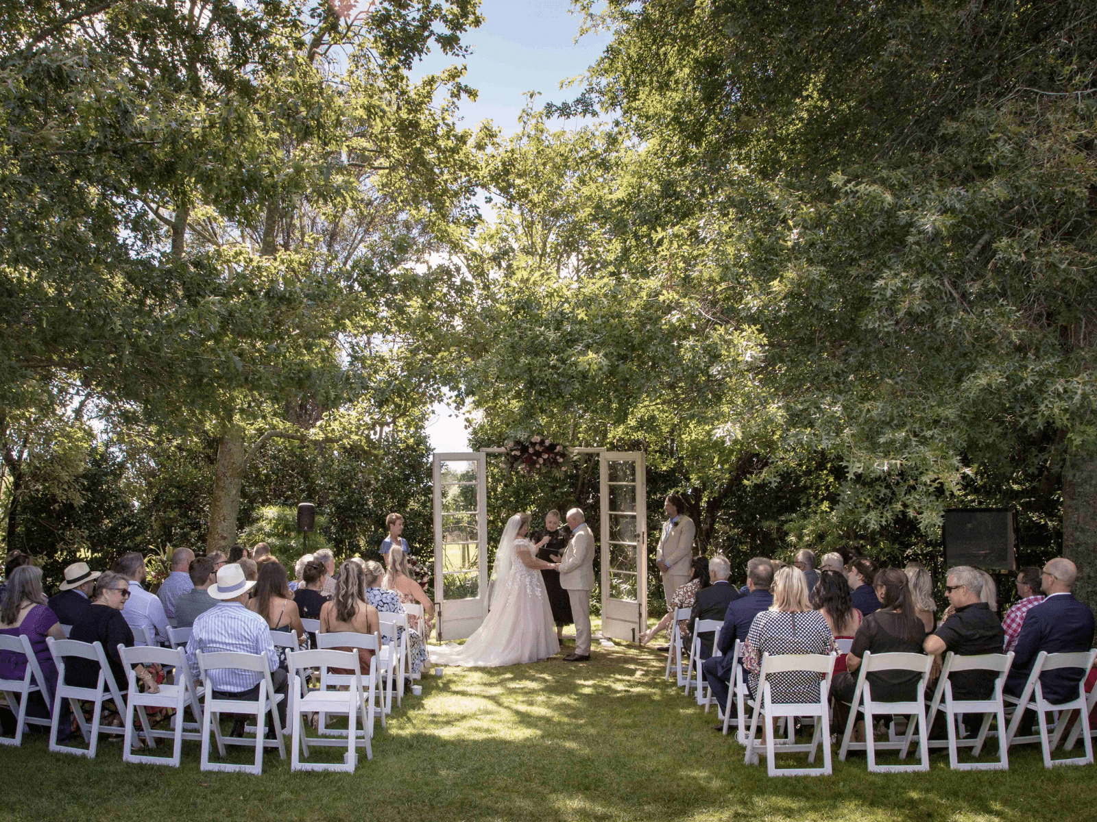 Beautiful sunny garden wedding setting with the bridge and groom at the alter.